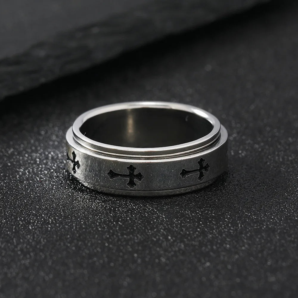 Close up view of the LuxCrux Rotatable Ring laying flat on the stoney ground.