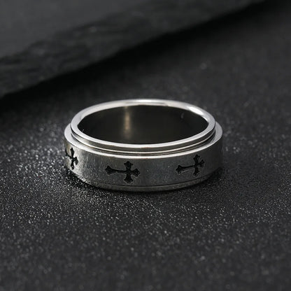 Close up view of the LuxCrux Rotatable Ring laying flat on the stoney ground.